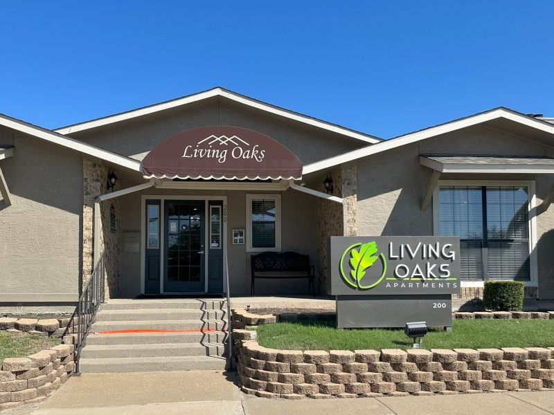 Living Oaks Apartments building exterior with leasing office entrance and sign